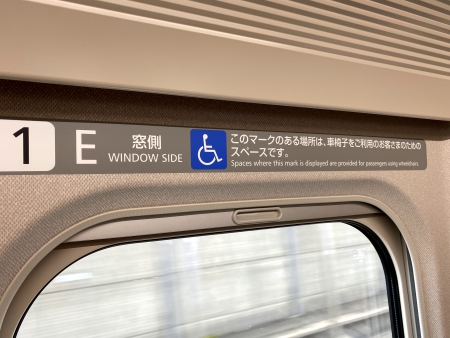 ▲写真:車椅子スペースには、窓枠付近に「このマークのある場所は、車椅子をご利用のお客さまのためのスペースです」と表示されています。