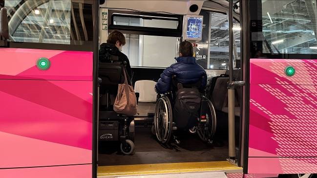 電動車いすの工藤と簡易電動車いすの土屋が車内に乗り込み、横向きで隣り合わせに並んでいる。