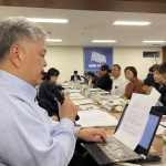 マイクで発言する佐藤事務局長
