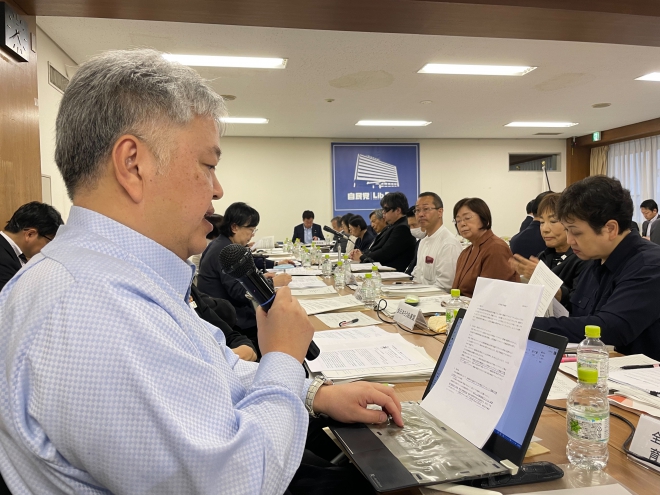 マイクで発言する佐藤事務局長
